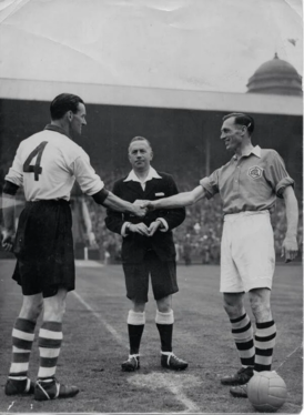 Captains Phil Taylor and Joe Mercer shake hands before the match.
