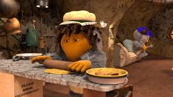A screenshot featuring Madame Cholet making some pastry dough while Wellington's in the background.