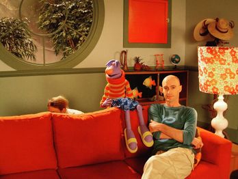 Shane sitting on the couch with Stretch/Puppet.