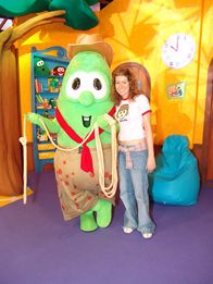 A woman standing next to Larry wearing a costume from an unknown episode