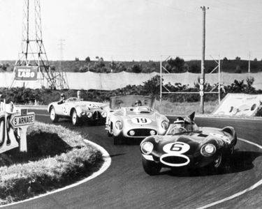 Hawthorn ahead of the Mercedes driven by Fangio and Moss.